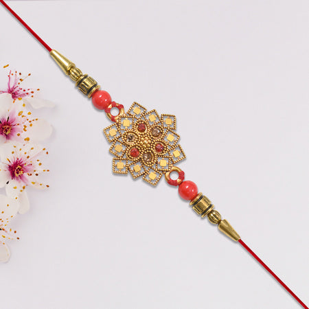 Traditional Golden Floral Rakhi With Intricate Design And Red Beads On Red Thread