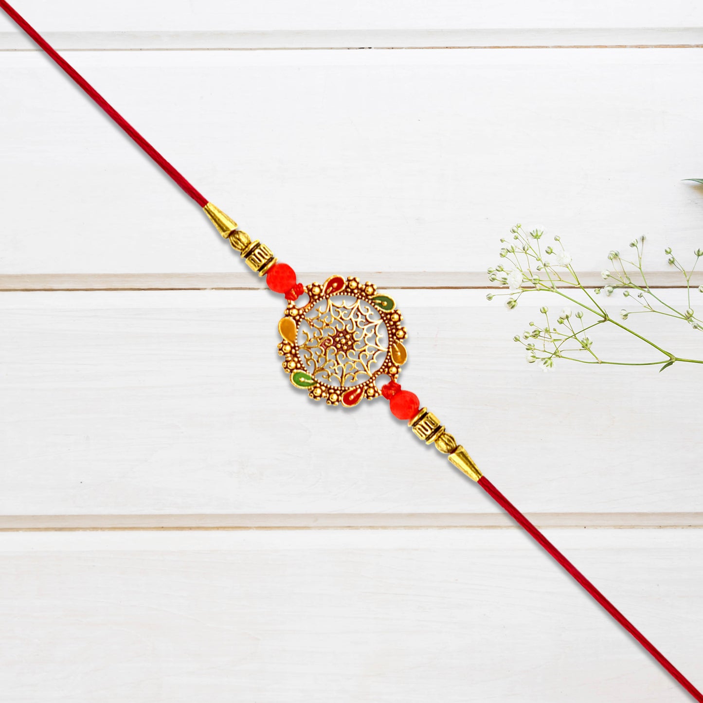 Intricately Designed Circular Rakhi With Multicolor Accents And Red Thread For Rakshabandhan