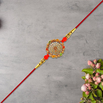 Intricately Designed Circular Rakhi With Multicolor Accents And Red Thread For Rakshabandhan