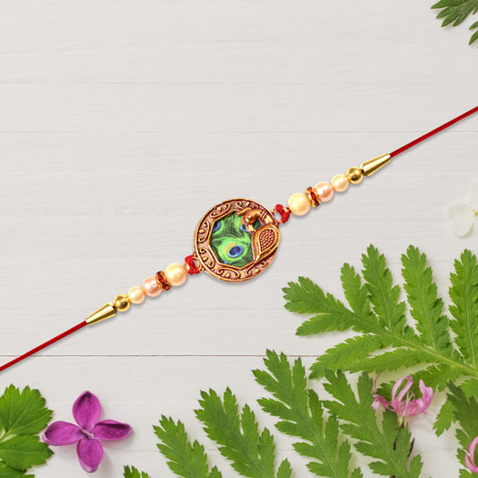 Elegant Rakhi With Peacock Feather Design And Pearl Bead Accents On Red Thread